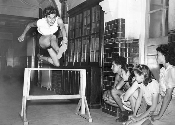Athlete Jean Desforges training in the corridor at Stratford Grammar School. 1947.